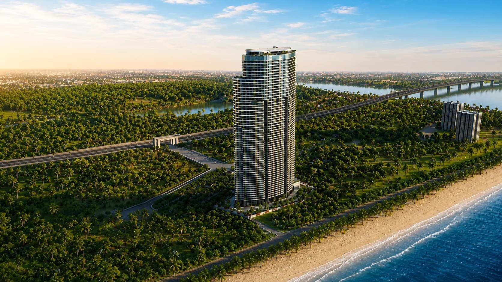 Aerial view of the Yamuna Sky City tower rising from coastal greenery, with National Highway 66 and a river bridge to the right and the Arabian Sea beach in the foreground